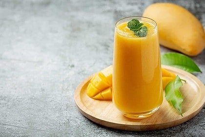 Refreshing homemade mango juice with fresh slices.