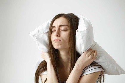 Disturbed sleep, woman covering ears from noise