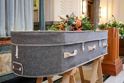 Biodegradable coffin adorned with natural flowers at eco-conscious funeral.